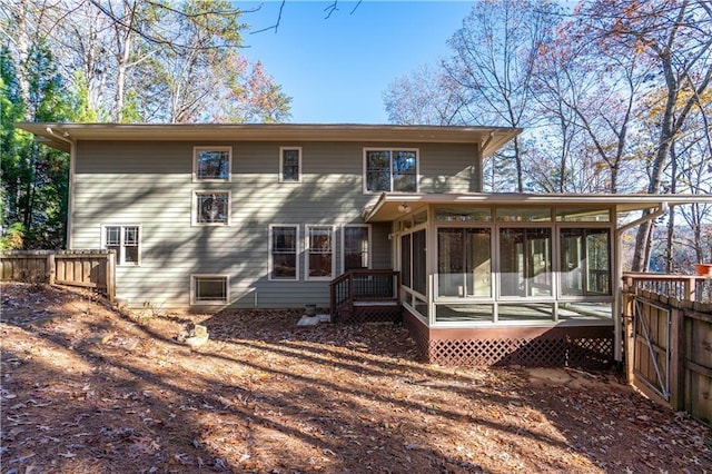 back of house featuring fence and a sunroom