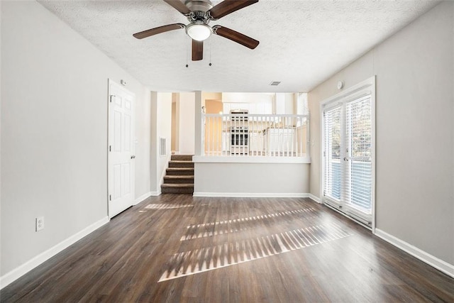 unfurnished living room featuring ceiling fan, dark hardwood / wood-style flooring, and a textured ceiling