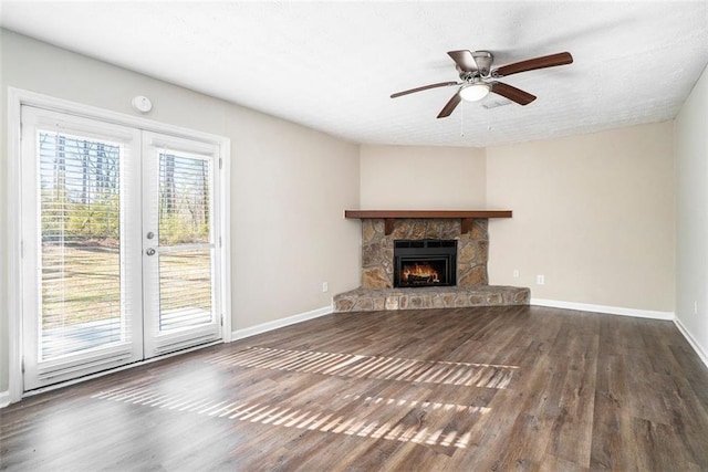 unfurnished living room with french doors, ceiling fan, a fireplace, and dark hardwood / wood-style floors