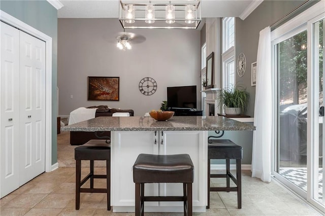 475 Chippenham Ct, Alpharetta, GA 30005 - kitchen with a chandelier, a breakfast bar area, hanging light fixtures, a kitchen island, and ornamental molding