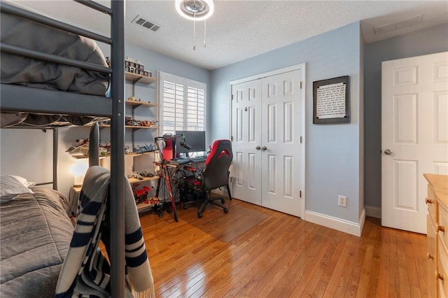 475 Chippenham Ct, Alpharetta, GA 30005 - bedroom featuring light wood-type flooring, a closet, a desk, and a textured ceiling