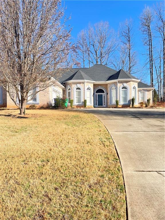 single story home with driveway and a front yard