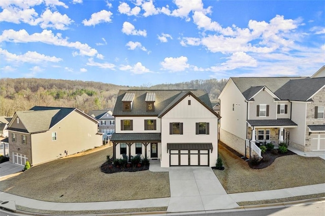 view of front of home with a garage, driveway, a residential view, and board and batten siding