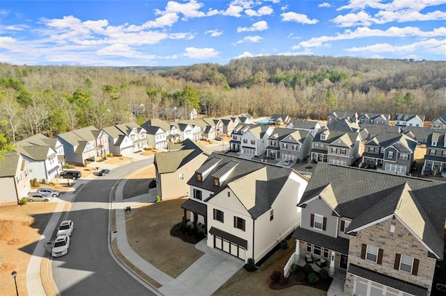 drone / aerial view featuring a residential view and a view of trees