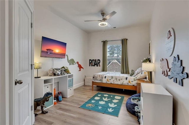 bedroom with light wood-style floors, visible vents, baseboards, and a ceiling fan