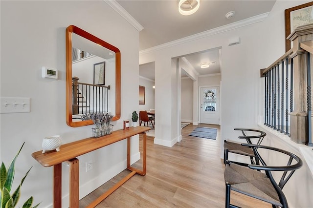 entrance foyer featuring ornamental molding, light wood-type flooring, baseboards, and stairs