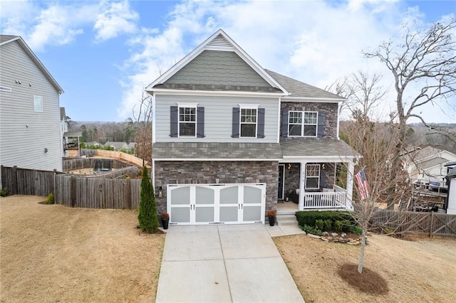 view of front of house with concrete driveway, a porch, an attached garage, and fence