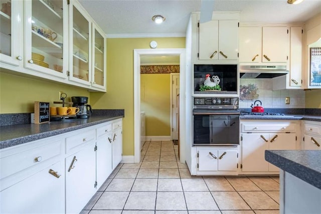 268 Tuck St, Cedartown, GA 30125 - kitchen with oven, under cabinet range hood, dark countertops, backsplash, and glass insert cabinets