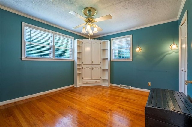 268 Tuck St, Cedartown, GA 30125 - unfurnished bedroom with multiple windows, light wood-style flooring, a textured ceiling, crown molding, and baseboards