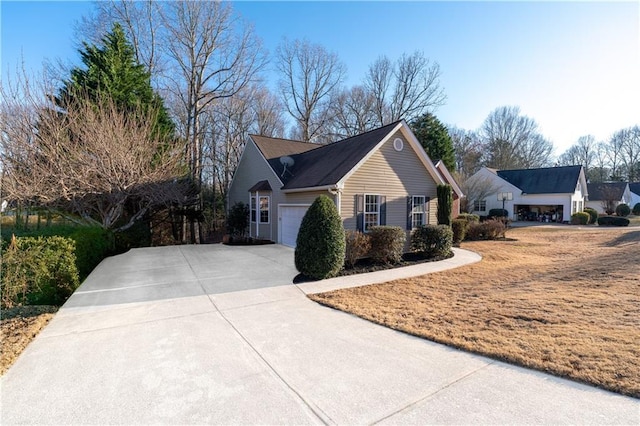 view of side of property featuring driveway and an attached garage