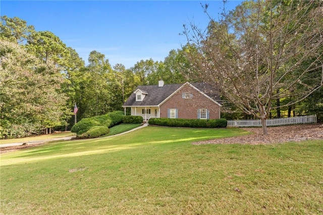 cape cod home with a front lawn