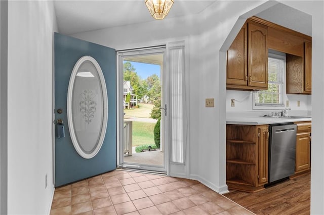 foyer featuring sink, light tile patterned floors, and a wealth of natural light