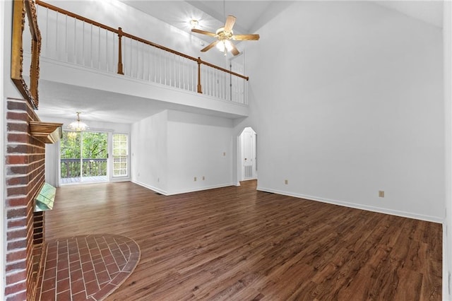 unfurnished living room with high vaulted ceiling, a fireplace, ceiling fan, and dark wood-type flooring