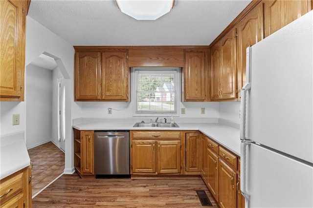 kitchen featuring sink, white refrigerator, dishwasher, and wood-type flooring