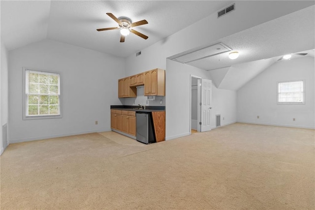 kitchen with lofted ceiling, ceiling fan, light carpet, and dishwasher