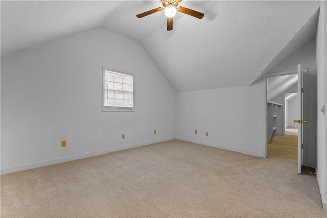 bonus room featuring ceiling fan, vaulted ceiling, and light colored carpet