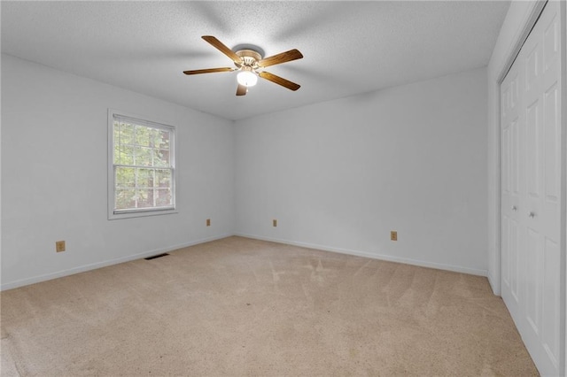 carpeted spare room with ceiling fan