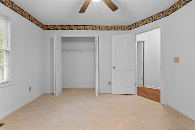 unfurnished bedroom featuring a closet, light carpet, and ceiling fan