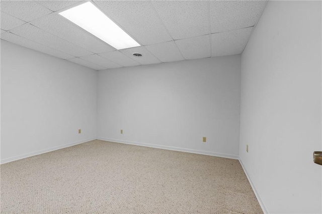 carpeted spare room with a drop ceiling