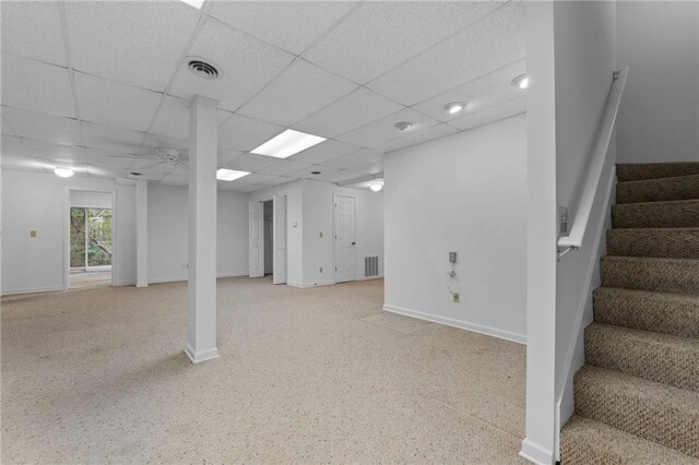 basement featuring ceiling fan and a paneled ceiling