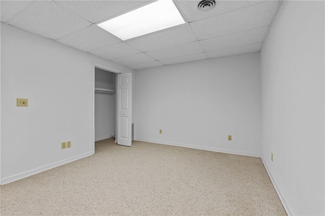 unfurnished bedroom featuring a closet and a drop ceiling