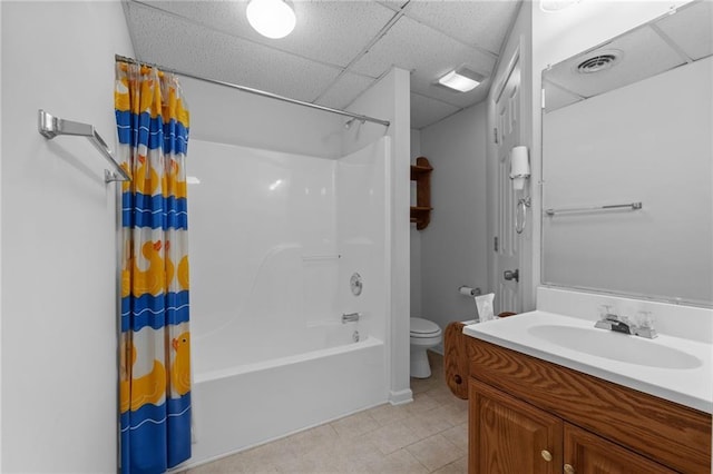 full bathroom with shower / tub combo with curtain, toilet, vanity, and a drop ceiling