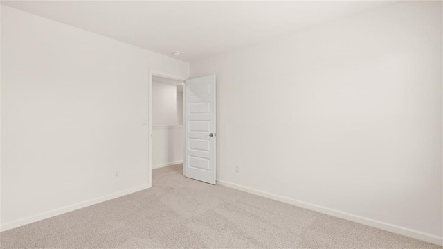 empty room with light carpet and baseboards