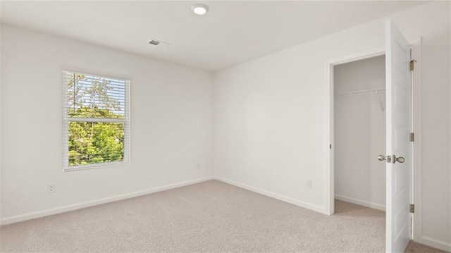 unfurnished bedroom featuring light carpet, baseboards, and a closet