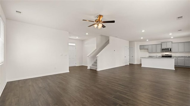 unfurnished living room with recessed lighting, dark wood-style flooring, stairway, baseboards, and a ceiling fan