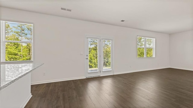 empty room with dark wood-type flooring and baseboards