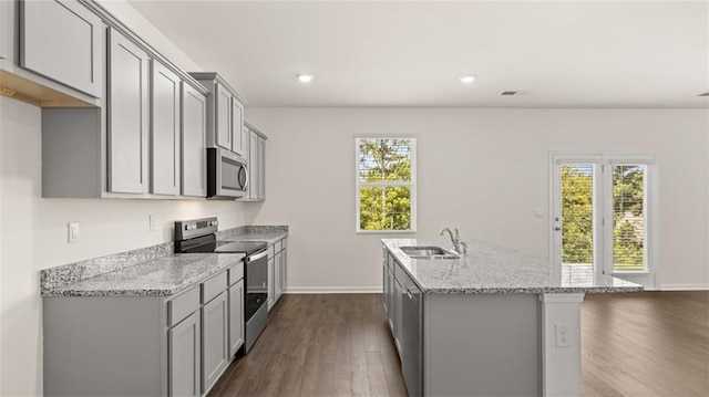 kitchen with appliances with stainless steel finishes, a sink, gray cabinetry, an island with sink, and recessed lighting