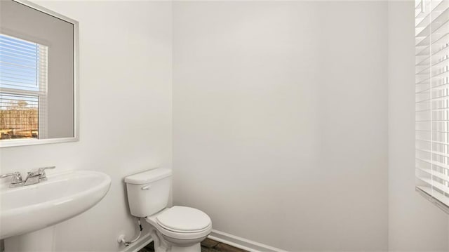 bathroom featuring a sink, toilet, and baseboards