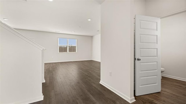 spare room with dark wood finished floors, baseboards, and recessed lighting