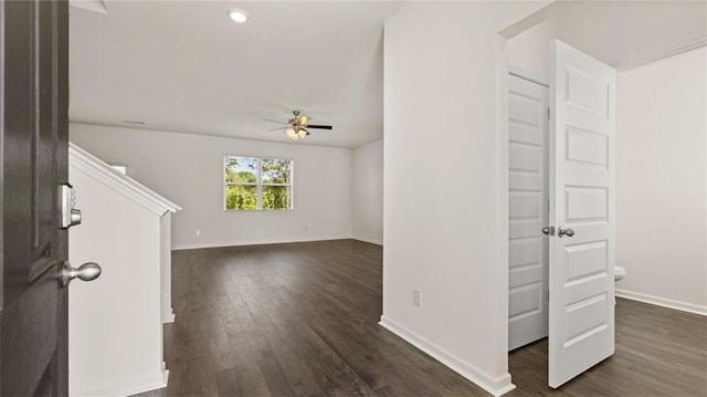 foyer with ceiling fan, dark wood-type flooring, and baseboards