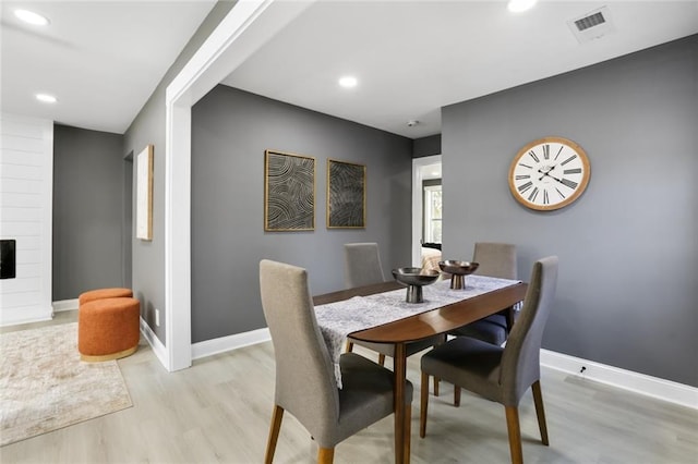 dining area featuring a fireplace and light hardwood / wood-style floors