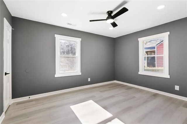 empty room featuring ceiling fan, light hardwood / wood-style flooring, and plenty of natural light