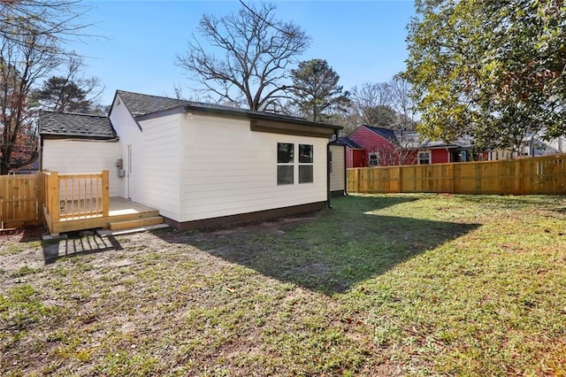 rear view of house featuring a deck and a lawn