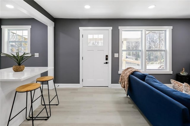 foyer entrance with light hardwood / wood-style floors and a healthy amount of sunlight