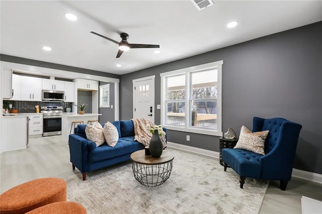 living room with ceiling fan and light wood-type flooring