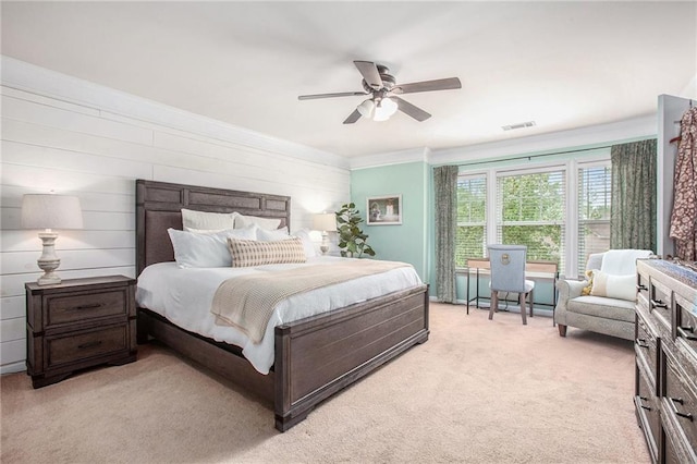 bedroom featuring visible vents, a ceiling fan, crown molding, and light colored carpet