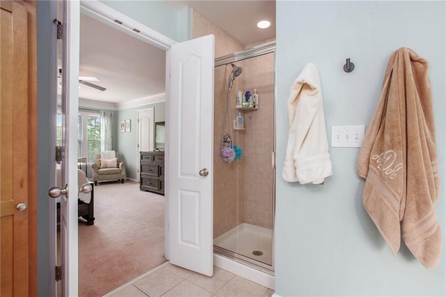 bathroom with connected bathroom, tile patterned floors, a ceiling fan, ornamental molding, and a stall shower