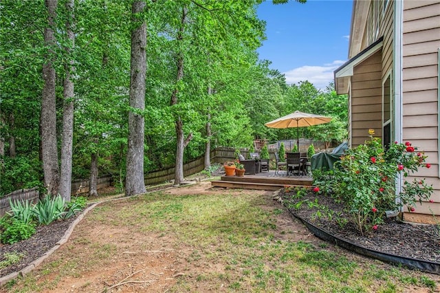 view of yard with outdoor dining area, a fenced backyard, and a deck