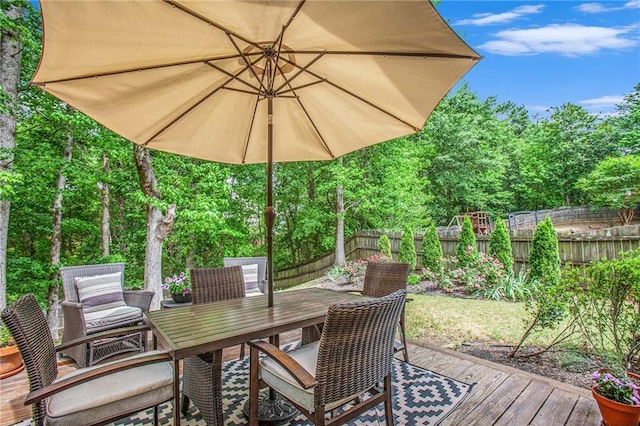 deck with a fenced backyard and outdoor dining space
