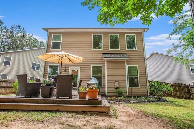 rear view of house with fence and a deck