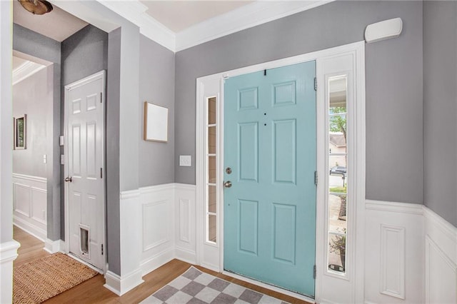 entryway with a decorative wall, wood finished floors, and a wainscoted wall