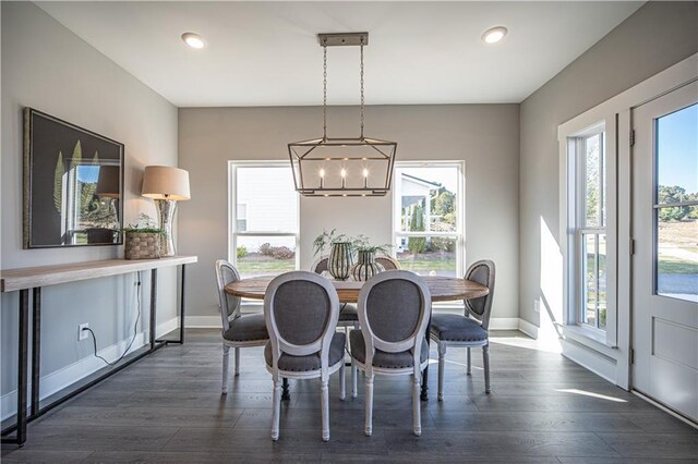 dining room with a healthy amount of sunlight, dark wood-type flooring, and a notable chandelier