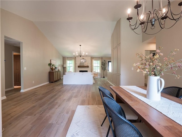 803 Plantation Ridge Overlook, Woodstock, GA 30188 - dining room featuring a chandelier, light wood finished floors, baseboards, high vaulted ceiling, and a large fireplace