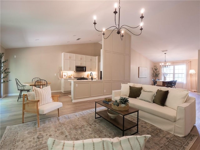 803 Plantation Ridge Overlook, Woodstock, GA 30188 - living area with a chandelier, vaulted ceiling, light wood-type flooring, and baseboards
