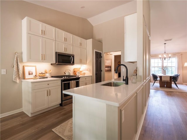 803 Plantation Ridge Overlook, Woodstock, GA 30188 - kitchen with stainless steel appliances, a sink, a chandelier, white cabinets, and vaulted ceiling