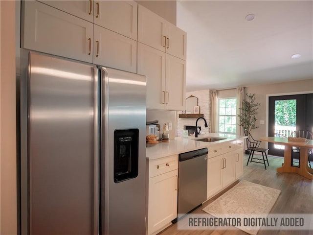 803 Plantation Ridge Overlook, Woodstock, GA 30188 - kitchen with appliances with stainless steel finishes, a sink, light countertops, light wood-style flooring, and white cabinets